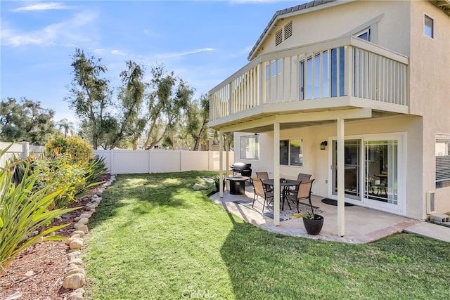 rear view of property featuring a lawn and a patio