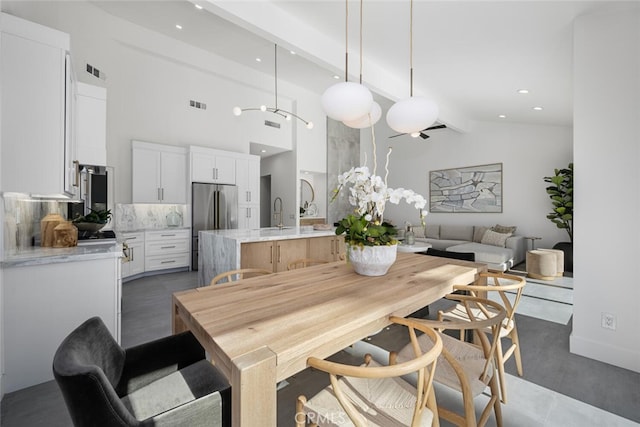 dining room with beamed ceiling, sink, and high vaulted ceiling