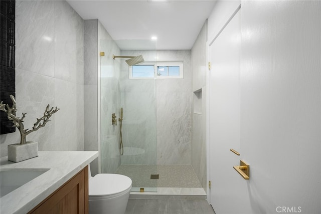 bathroom featuring vanity, toilet, and tiled shower