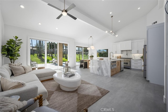 living room featuring concrete flooring, ceiling fan, sink, and high vaulted ceiling