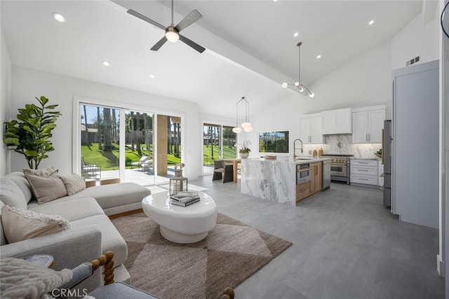 living room featuring concrete flooring, ceiling fan, sink, and high vaulted ceiling