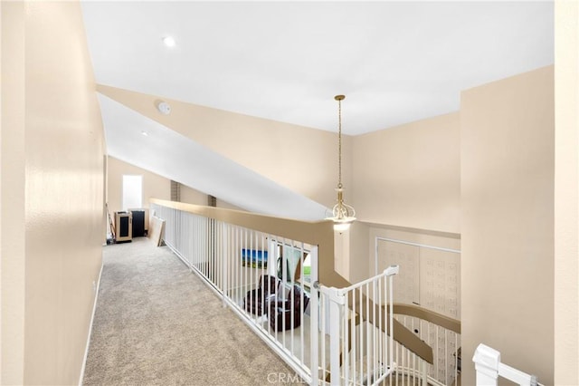 hallway featuring light colored carpet and vaulted ceiling