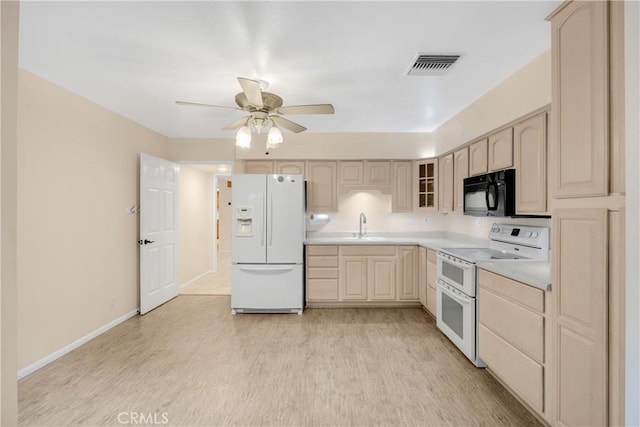 kitchen featuring light brown cabinetry, white appliances, light hardwood / wood-style floors, and sink