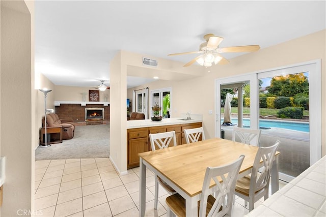 carpeted dining room with ceiling fan and sink