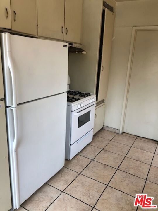 kitchen with white appliances and light tile patterned floors