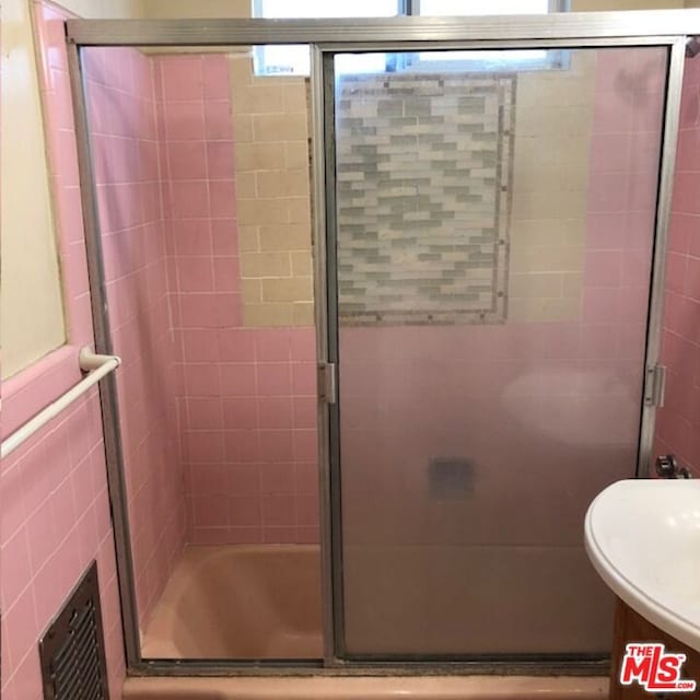 bathroom featuring shower / bath combination with glass door