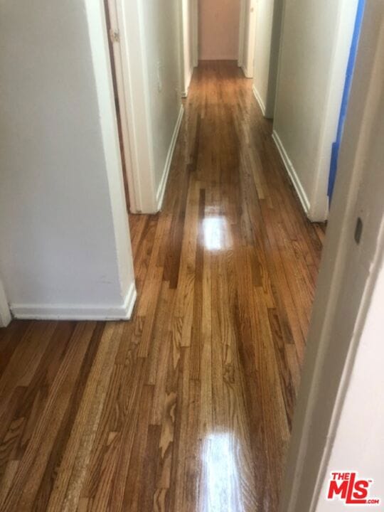 hallway with dark hardwood / wood-style flooring