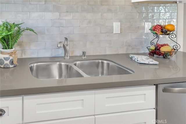 kitchen featuring dishwasher, tasteful backsplash, white cabinetry, and sink