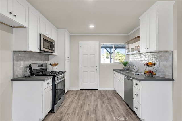 kitchen with stainless steel appliances, white cabinetry, and sink