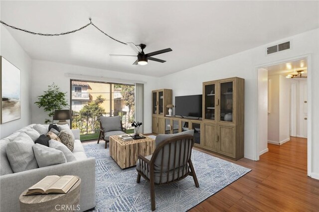 living room with ceiling fan and light hardwood / wood-style flooring