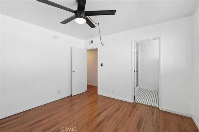 spare room with visible vents, baseboards, ceiling fan, and wood finished floors