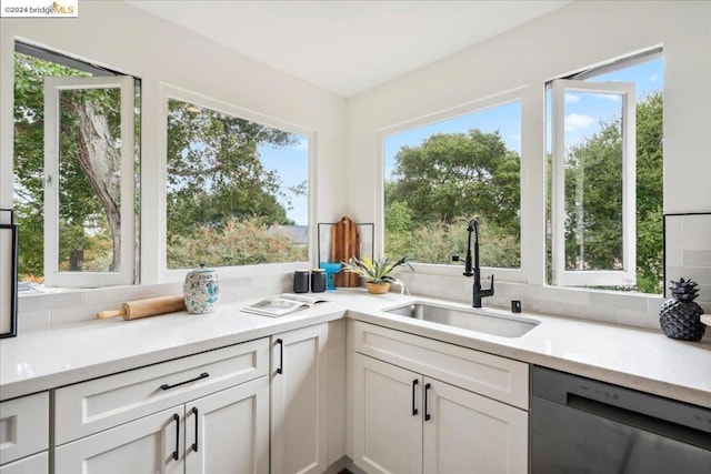 kitchen with sink, a wealth of natural light, white cabinets, and dishwasher