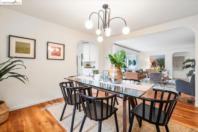 dining area with a chandelier and light hardwood / wood-style flooring