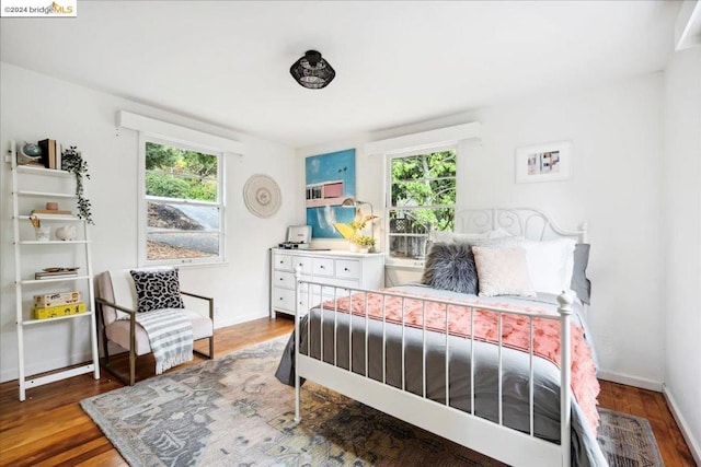 bedroom with multiple windows and hardwood / wood-style floors