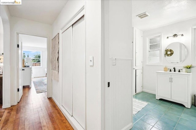 hallway featuring sink and wood-type flooring