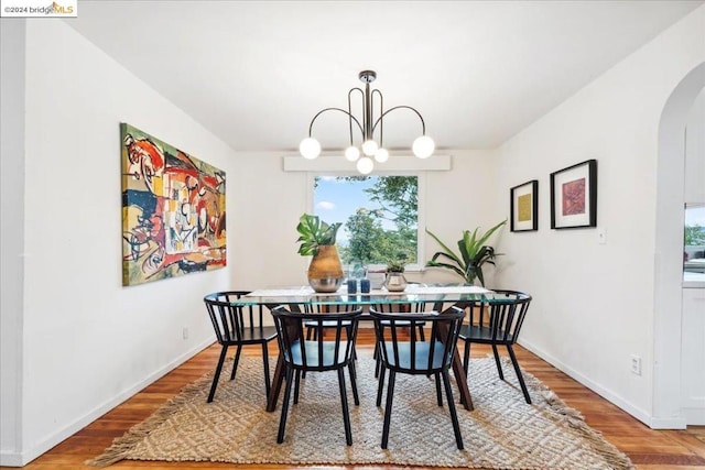 dining area featuring an inviting chandelier and hardwood / wood-style flooring