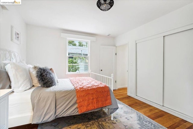 bedroom with hardwood / wood-style floors and a closet