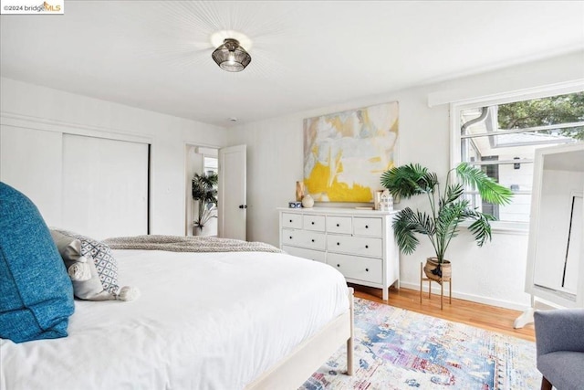 bedroom with wood-type flooring and a closet