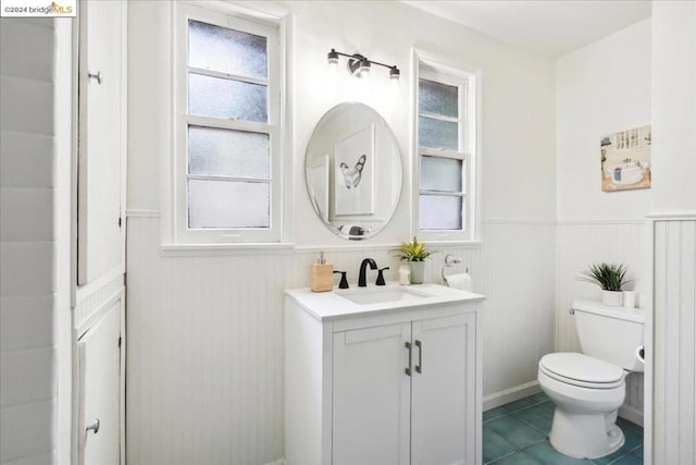 bathroom with tile patterned flooring, vanity, and toilet