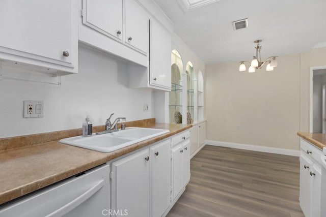 kitchen featuring decorative light fixtures, dishwasher, sink, white cabinets, and a chandelier