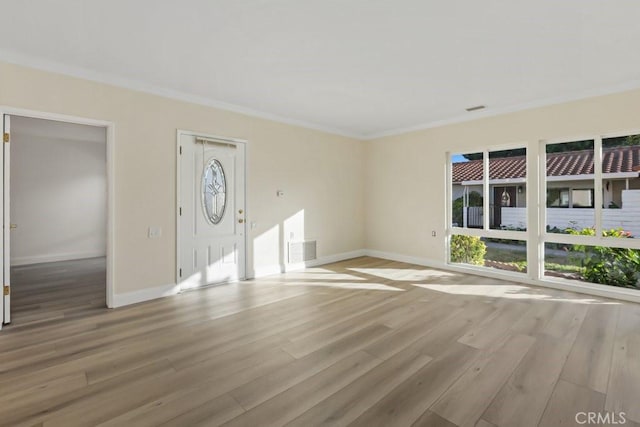 unfurnished living room featuring ornamental molding and light hardwood / wood-style floors