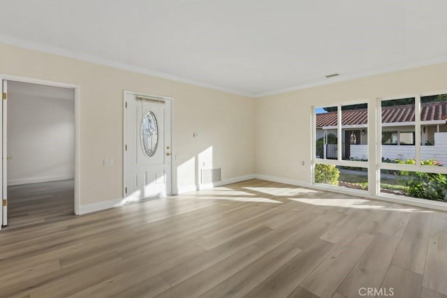 unfurnished living room with crown molding and light hardwood / wood-style flooring