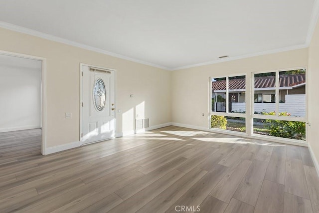 unfurnished living room featuring light hardwood / wood-style floors, a wealth of natural light, and crown molding