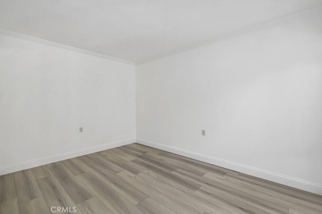 empty room featuring light hardwood / wood-style flooring and ornamental molding