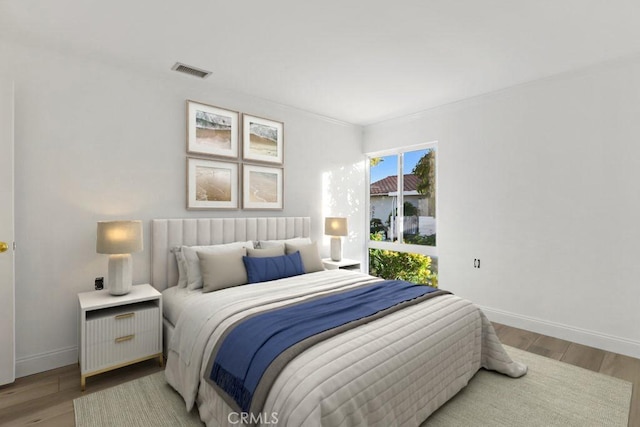 bedroom with light wood-type flooring and ornamental molding