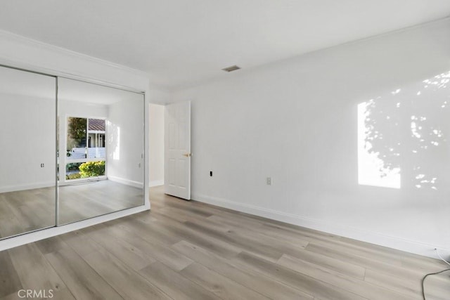 unfurnished bedroom featuring a closet and light hardwood / wood-style flooring