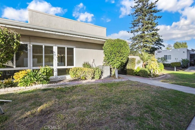 view of home's exterior with a lawn and central air condition unit