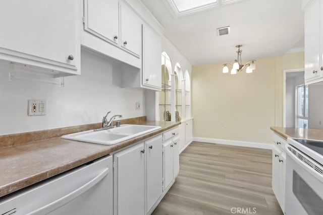 kitchen with decorative light fixtures, sink, dishwashing machine, and white cabinets