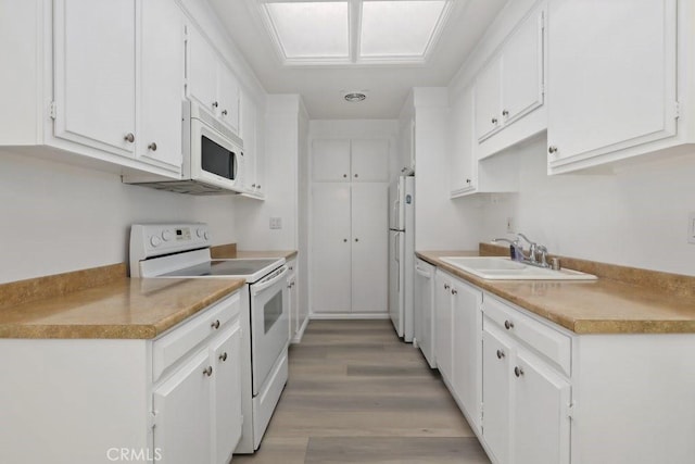 kitchen featuring light wood-type flooring, sink, white appliances, and white cabinetry