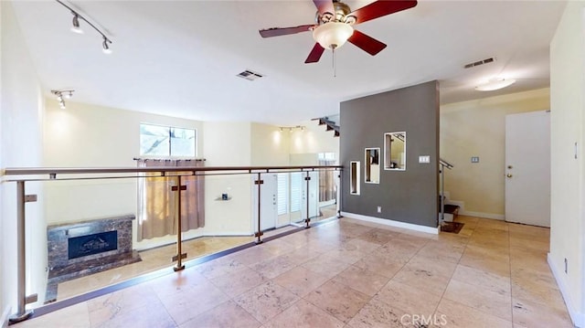 living room with ceiling fan and a fireplace