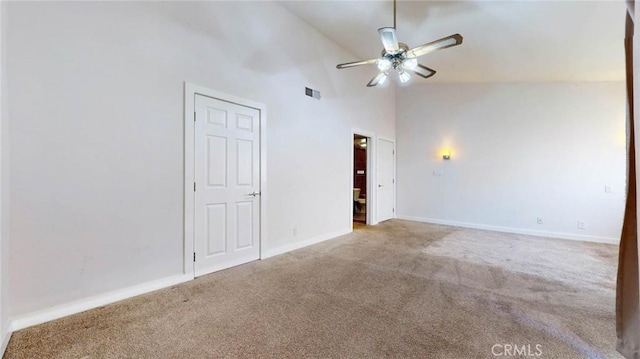 carpeted spare room with high vaulted ceiling and ceiling fan