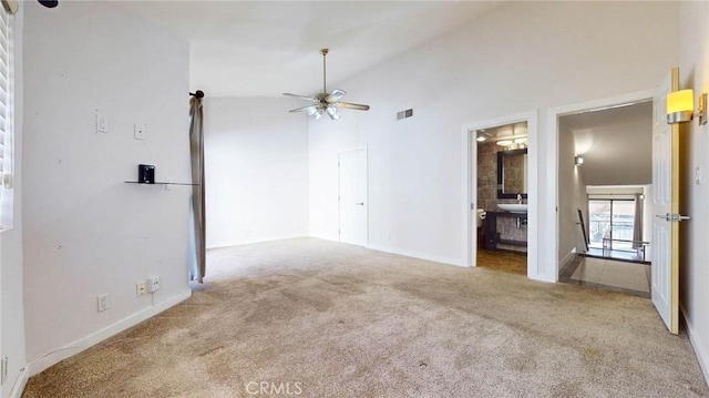 carpeted empty room with ceiling fan, high vaulted ceiling, and sink