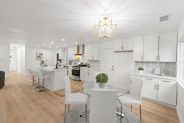 dining room with an inviting chandelier and light hardwood / wood-style floors