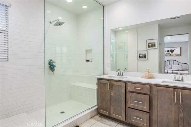 bathroom featuring vanity, tile patterned flooring, and tiled shower