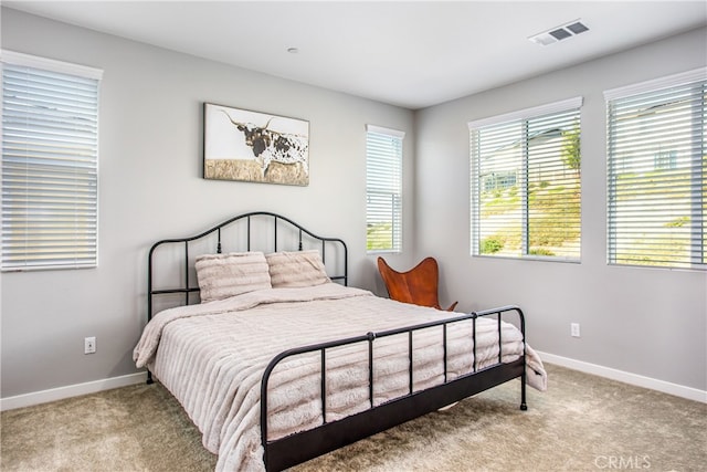 carpeted bedroom with visible vents and baseboards