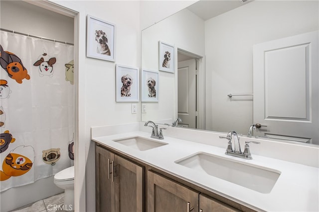 bathroom featuring toilet, vanity, and tile patterned flooring