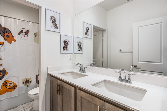 bathroom featuring a shower with shower curtain, double vanity, a sink, and toilet