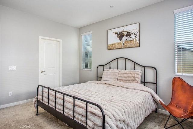 carpeted bedroom with baseboards and multiple windows
