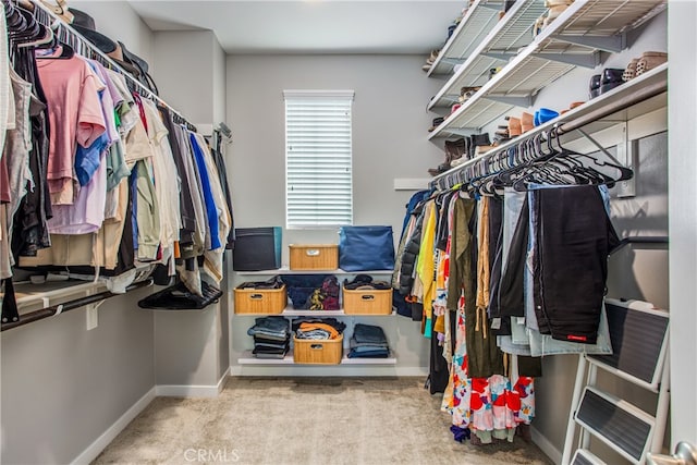 walk in closet with light carpet