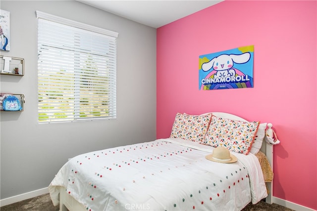 carpeted bedroom featuring multiple windows and baseboards