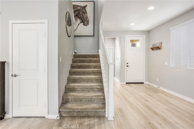 stairs featuring recessed lighting, wood finished floors, and baseboards