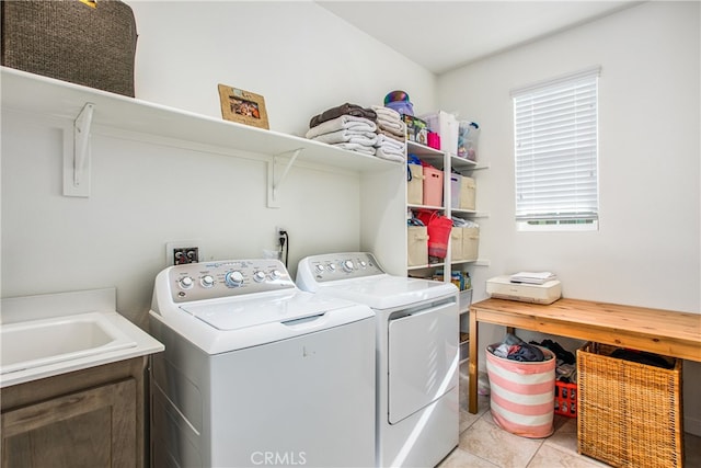 laundry room featuring cabinets, light tile patterned floors, and washing machine and clothes dryer