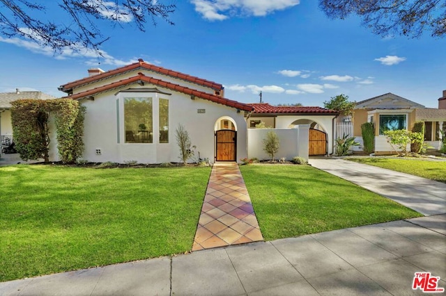 mediterranean / spanish home with a front yard