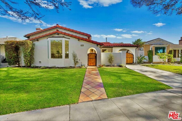 mediterranean / spanish house featuring a front lawn