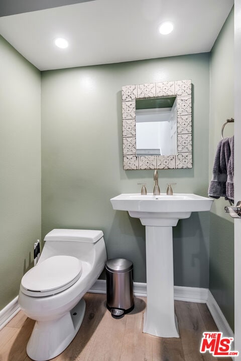 bathroom featuring hardwood / wood-style floors and toilet