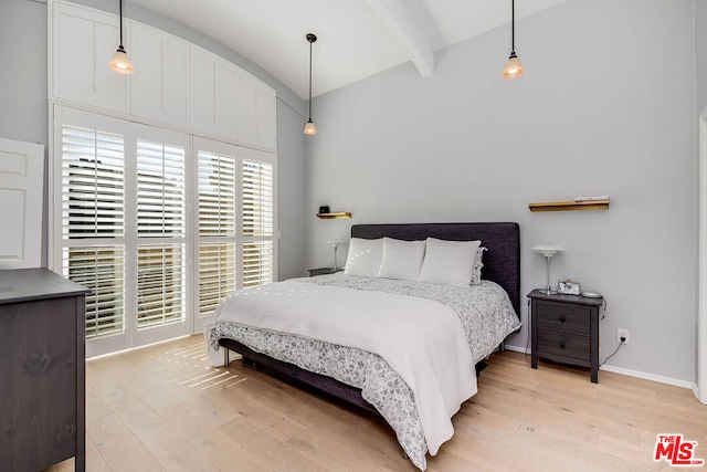 bedroom with vaulted ceiling with beams and light hardwood / wood-style floors